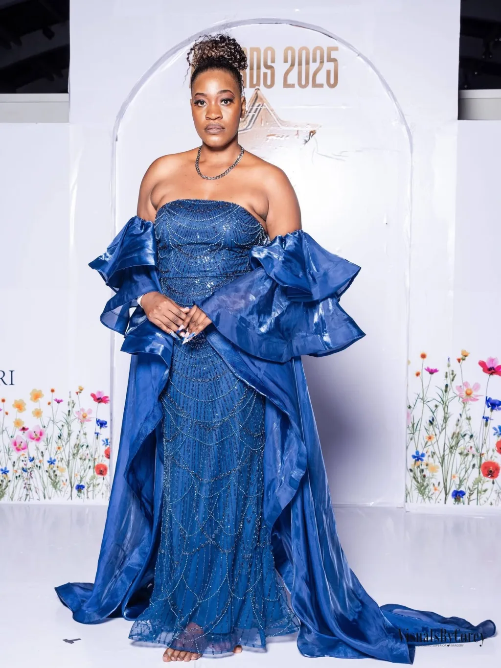 A guest on the red carpet in a blue gown