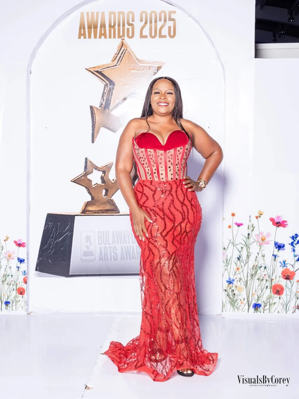 A guest on the red carpet in a red gown