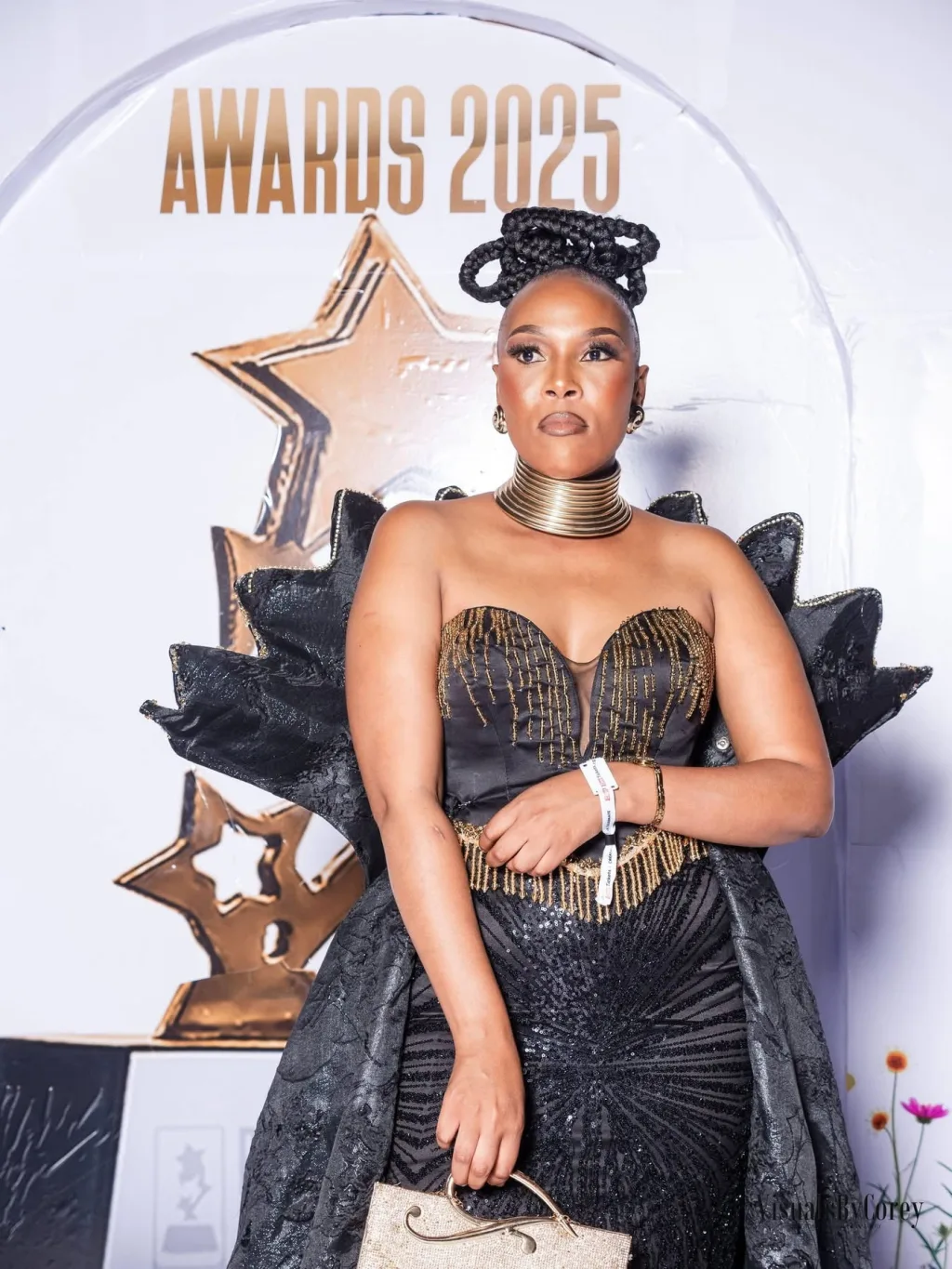 A guest on the red carpet beside the awards backdrop
